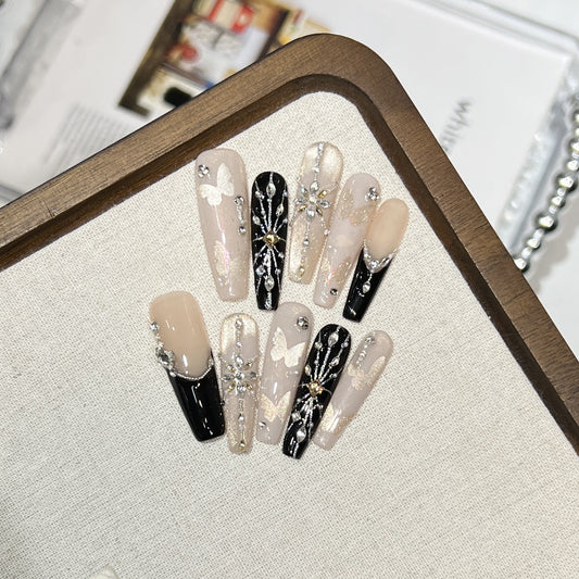 Butterfly Crystal press-on nails in almond — worn on hand, close-up