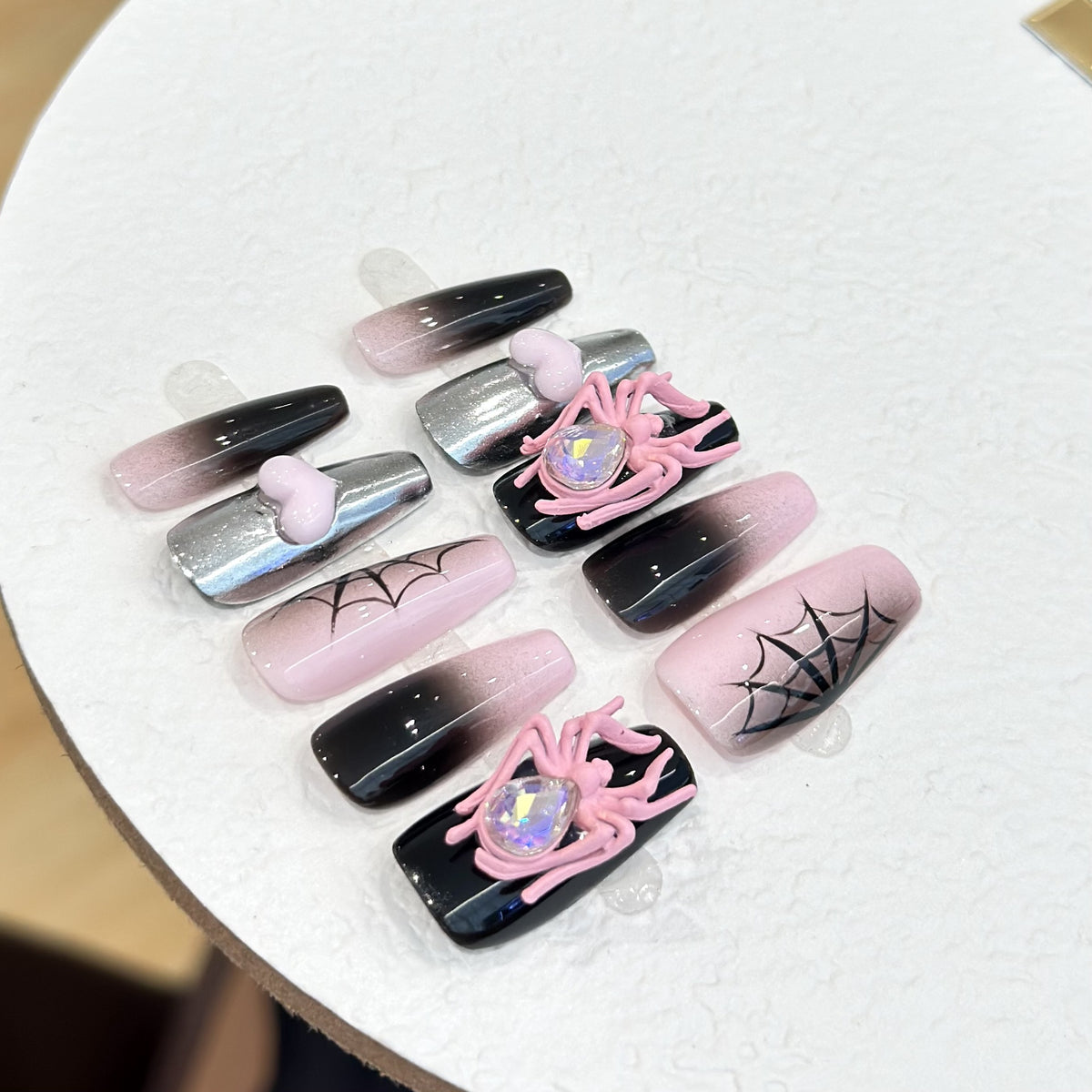 Black & Pink Spider press-on nails in almond — worn on both hands, full look