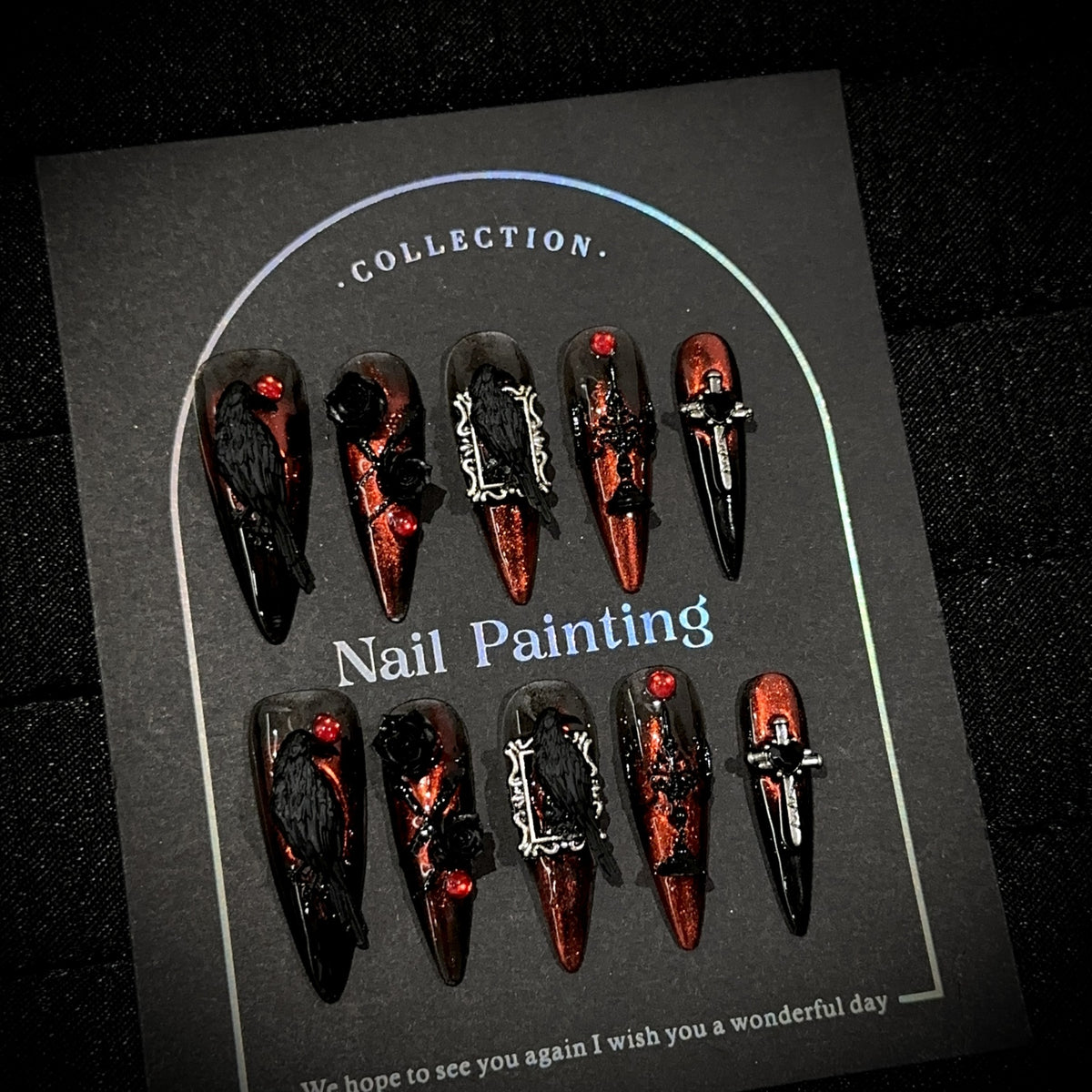 Raven Song Long Stiletto Halloween press-on nails in almond — worn on hand, close-up