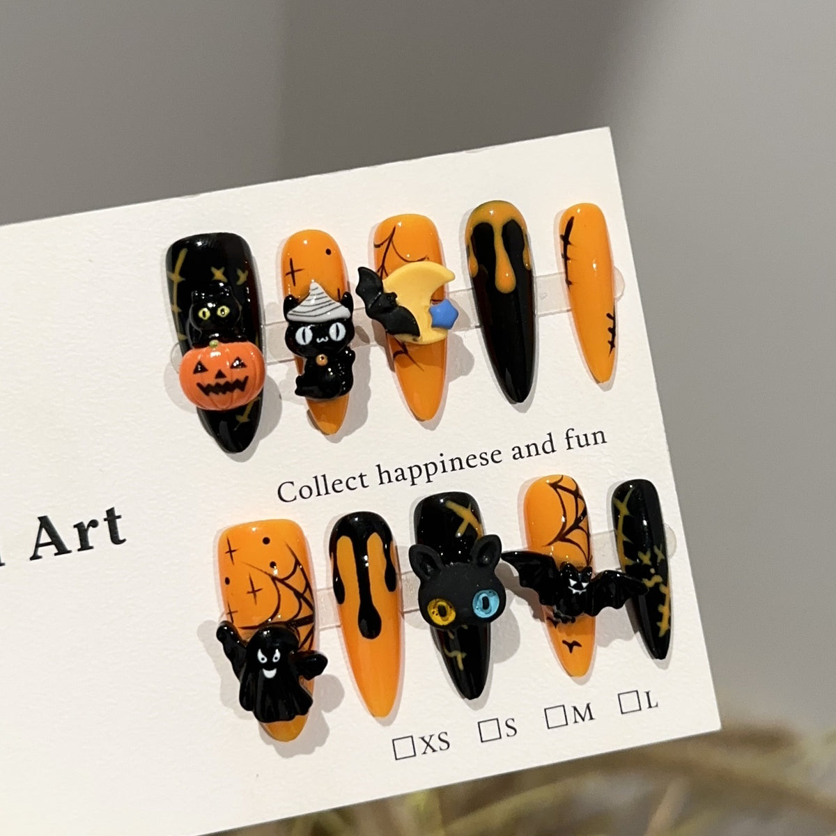 Spooky Pumpkin Long Oval Halloween press-on nails in almond — worn on hand, close-up