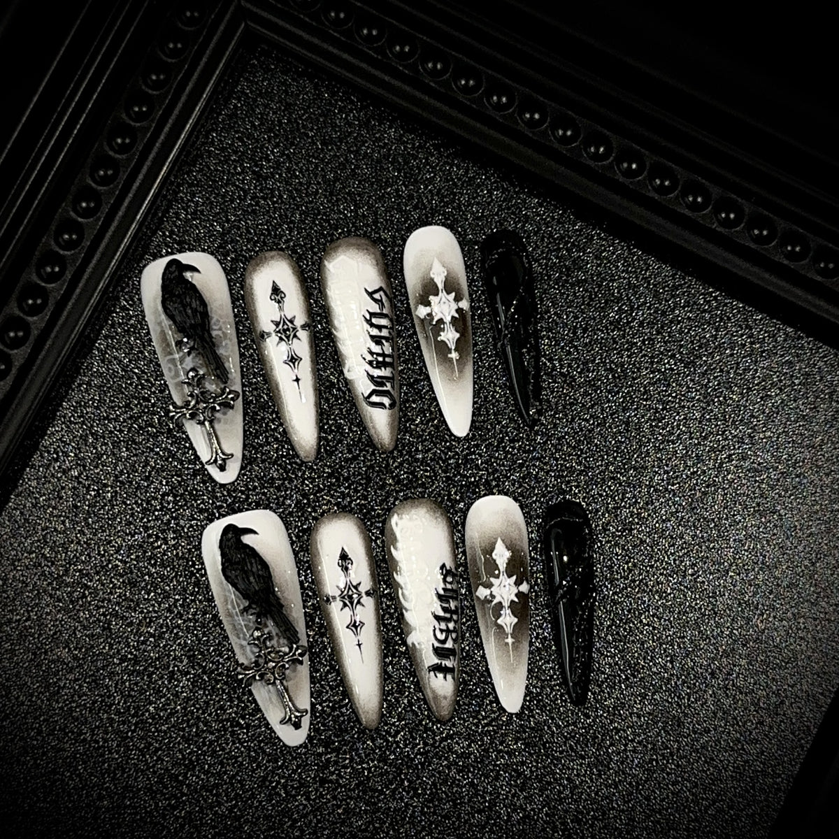 Black Raven Oath Long Stiletto Halloween press-on nails in almond — worn on hand, close-up