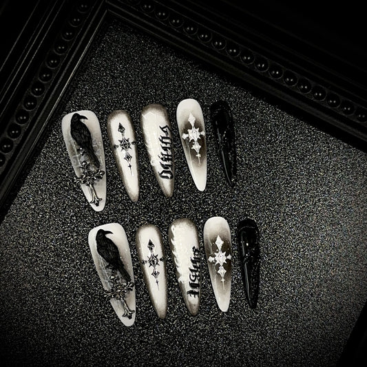 Black Raven Oath Long Stiletto Halloween press-on nails in almond — worn on hand, close-up