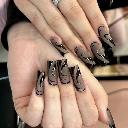 Black press-on nails in almond — worn on hand, close-up