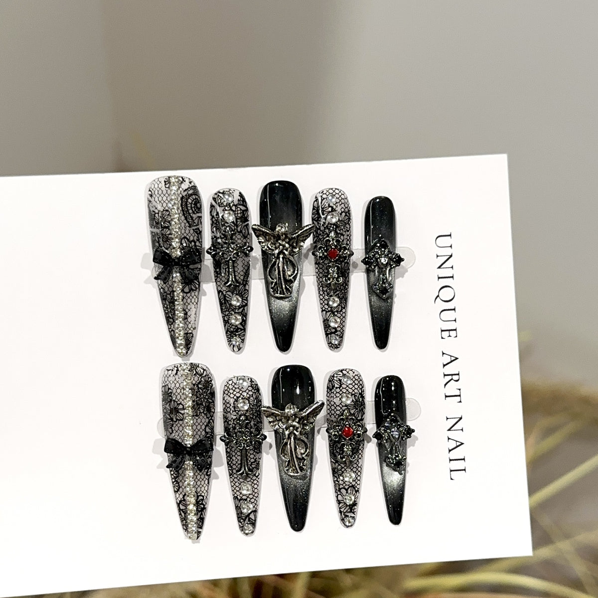 Fallen Angel Long Stiletto Gothic press-on nails in almond — worn on both hands, full look