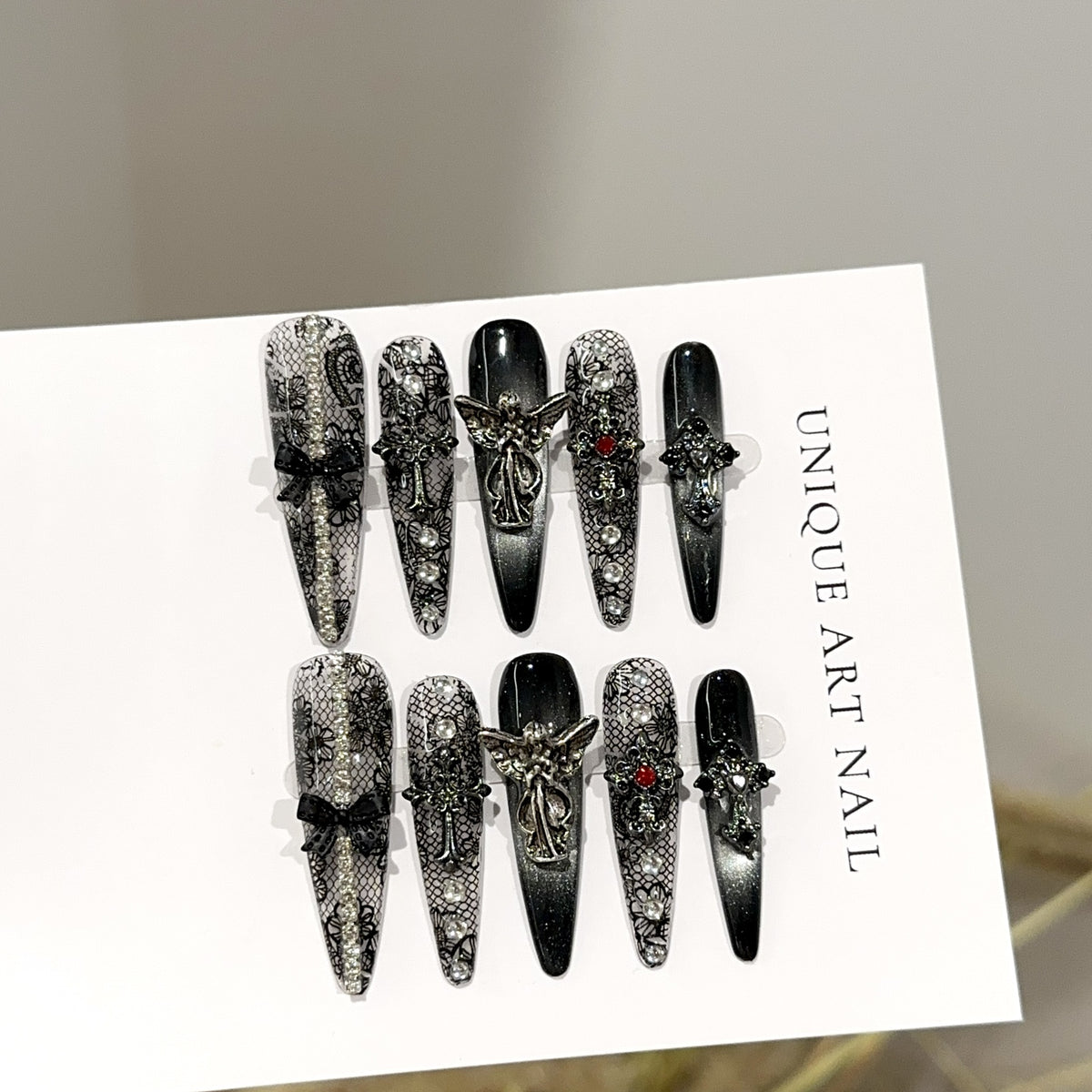 Fallen Angel Long Stiletto Gothic press-on nails in almond — worn on hand, close-up